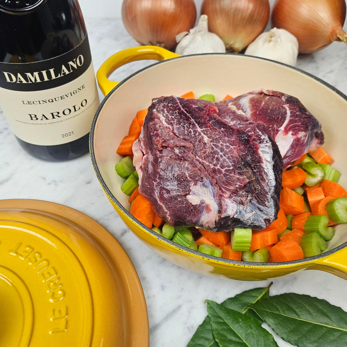Grass-fed beef cheeks brasato prep in a yellow Le Creuset Dutch oven with carrots, celery, onions, bay leaves, and Barolo — Wishbone Heritage Farms, Saint George, SC