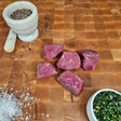 Grass-fed beef for kabobs on an end-grain butcher block with flake salt, cracked pepper, and chimichurri — Wishbone Heritage Farms, Saint George, SC