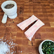 Grass-fed beef canoe cut marrow bones on an end-grain butcher block with flake salt, cracked pepper, and chimichurri — Wishbone Heritage Farms, Saint George, SC