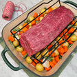 Grass-fed beef eye round roast in a green Le Creuset roasting pan with potatoes, carrots, garlic, rosemary, and butcher's twine — Wishbone Heritage Farms, Saint George, SC