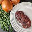 Grass-fed beef kidney on a white plate with fresh rosemary and yellow onions — Wishbone Heritage Farms, Saint George, SC