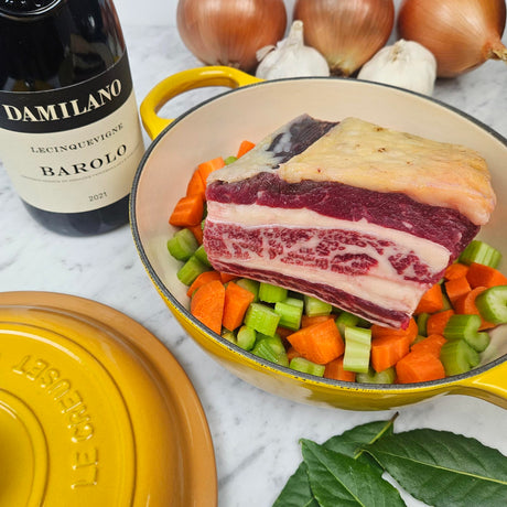 Grass-fed beef short ribs brasato prep in a yellow Le Creuset Dutch oven with carrots, celery, onions, bay leaves, and Barolo — Wishbone Heritage Farms, Saint George, SC