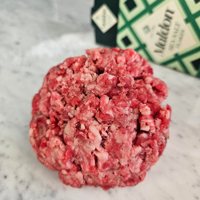 Fresh grass-fed ground beef keto blend on white marble with Maldon sea salt — Wishbone Heritage Farms, South Carolina