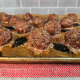 Oven-roasted grass-fed beef meatballs on a parchment-lined sheet pan with crisped basil leaves and browned Parmesan — Wishbone Heritage Farms, Saint George, SC