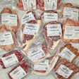 Wishbone Heritage Farms Grill Master's Dream Bundle — bone-in NY strip steaks, bone-in ribeye steaks, tomahawk pork rib chops, chicken wings, boneless skin-on chicken breasts, boneless skin-on chicken thighs, ground beef, smoky andouille, and roasted garlic bratwurst in vacuum-sealed packaging — Saint George, SC