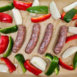 Raw heritage pork hot Italian sausage links on a sheet pan with red and green peppers and onions, ready to roast — Wishbone Heritage Farms, South Carolina