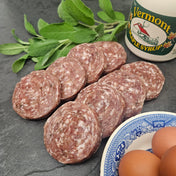 Raw pasture raised maple pork breakfast sausage patties on slate with Vermont maple syrup, fresh sage, and eggs