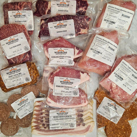 Wishbone Heritage Farms no bones about it bundle — flat iron steak, Denver steak, boneless skinless chicken breast, boneless chicken thighs, boneless center cut pork chops, uncured smoked slab bacon, beef taco mix, maple breakfast sausage, and spicy chicken patties in vacuum-sealed packaging — Saint George, SC