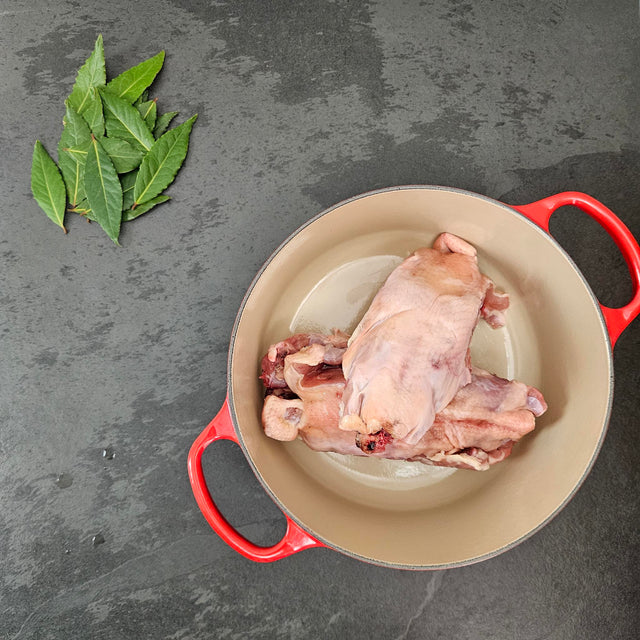 Pasture-raised chicken backs in a red Le Creuset Dutch oven with fresh bay leaves — Wishbone Heritage Farms, Saint George, SC