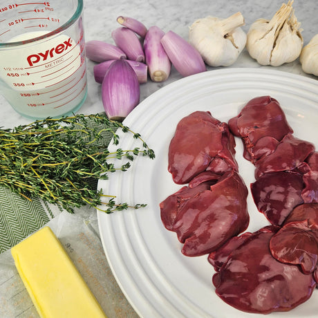Pasture-raised chicken livers on a white plate with shallots, garlic, fresh thyme, butter, and milk — Wishbone Heritage Farms, Saint George, SC