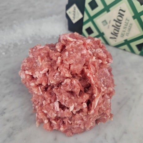 Fresh pasture-raised ground chicken on white marble with Maldon sea salt — Wishbone Heritage Farms, South Carolina