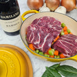 Pasture-raised heritage pork cheeks brasato prep in a yellow Le Creuset Dutch oven with carrots, celery, onions, bay leaves, and Barolo — Wishbone Heritage Farms, Saint George, SC