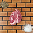 Pasture-raised heritage breed pork coppa steak on an end-grain butcher block with flake salt and cracked pepper — Wishbone Heritage Farms, Saint George, SC