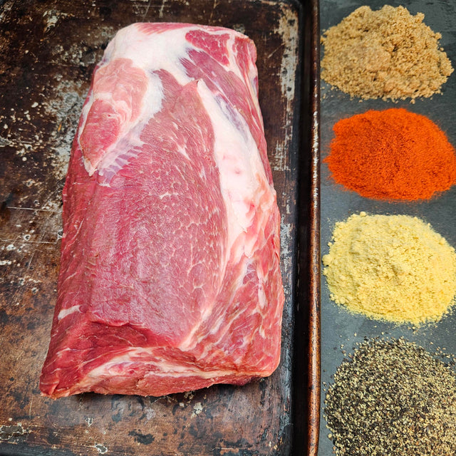Pasture-raised heritage breed pork coppa on a seasoned sheet pan with dry rub spices — brown sugar, paprika, mustard, and black pepper — Wishbone Heritage Farms, Saint George, SC