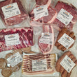 Wishbone Heritage Farms pasture-raised heritage breed pork variety pack — pork shoulder butt, center cut pork chops, St. Louis style ribs, boneless sirloin pork chops, uncured smoked slab bacon, maple breakfast sausage, hot Italian sausage, and roasted garlic bratwurst in vacuum-sealed packaging — Saint George, SC