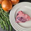 Pasture-raised heritage pork heart on a white plate with fresh rosemary and yellow onions — Wishbone Heritage Farms, Saint George, SC